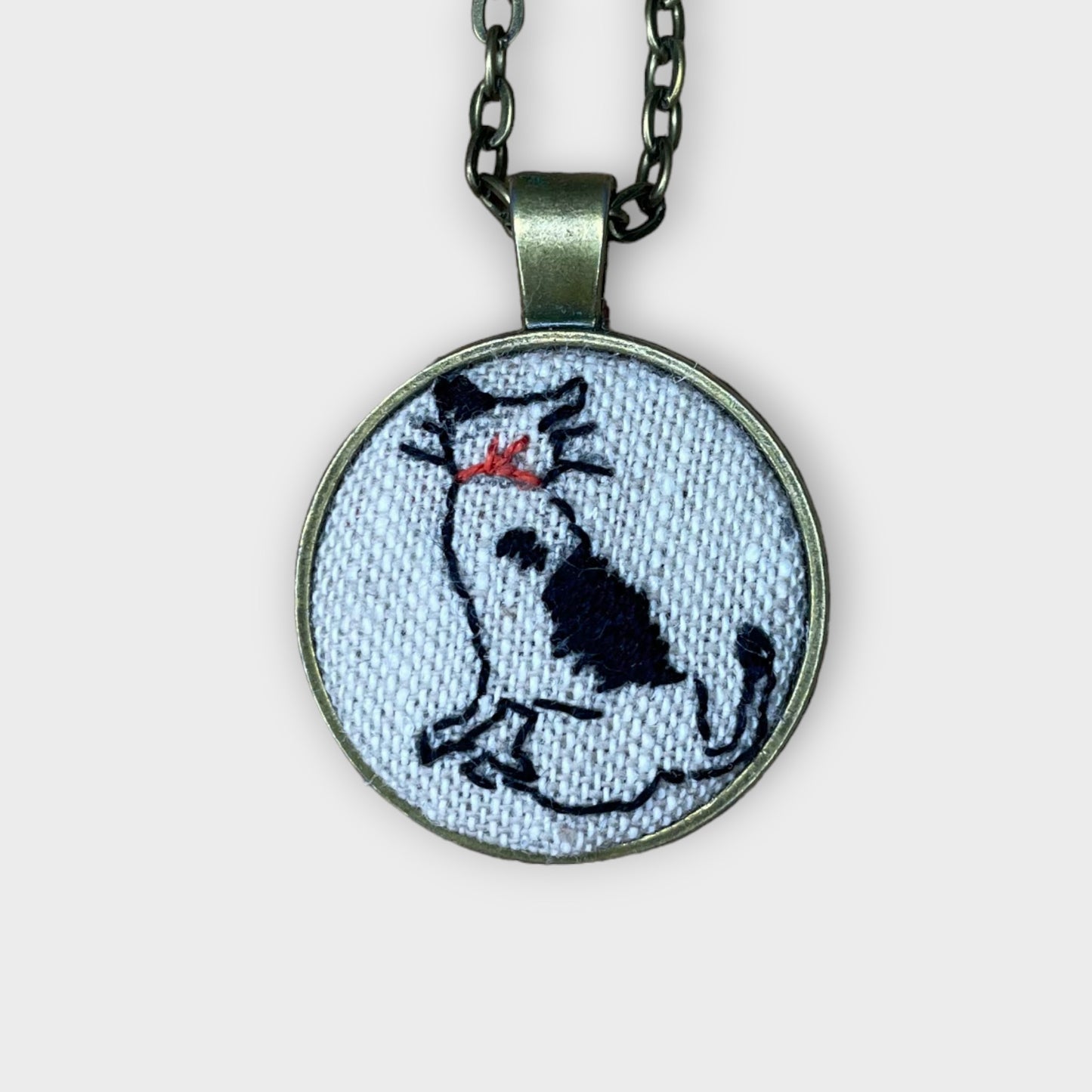 Hand embroidered cat looking away necklace